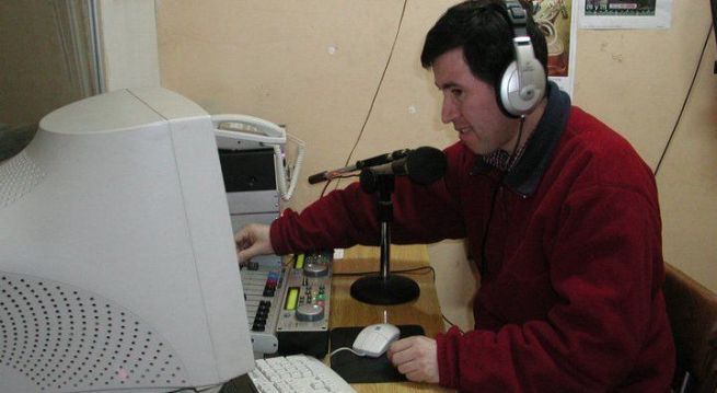 Una de las personas con discapacidad que trabaja en la radio operando los equipos computacionales.