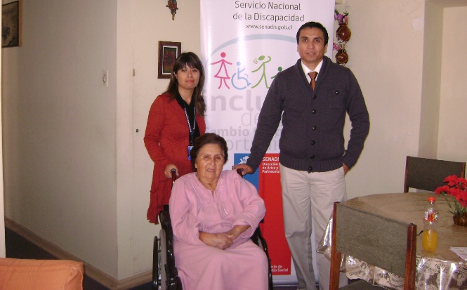 El Director Regional del Senadis Arica junto a una de las personas beneficiadas con silla de ruedas.