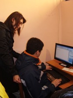 En la foto aparece la Coordinadora Regional junto a una persona con discapacidad en un computador