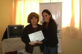 La supervisora del proyecto Jocelyn Franco entrega certificado a una de las personas beneficiadas 