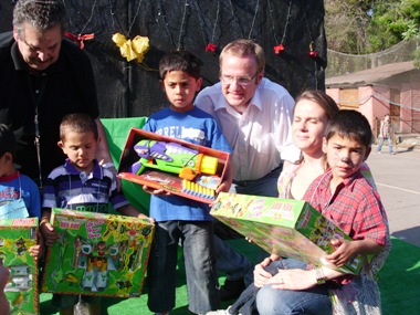 Ministro Kast, Ximena Rivas y Nelson Weitzel entregan regalos a los niños sordos que participaron en la fiesta de navidad