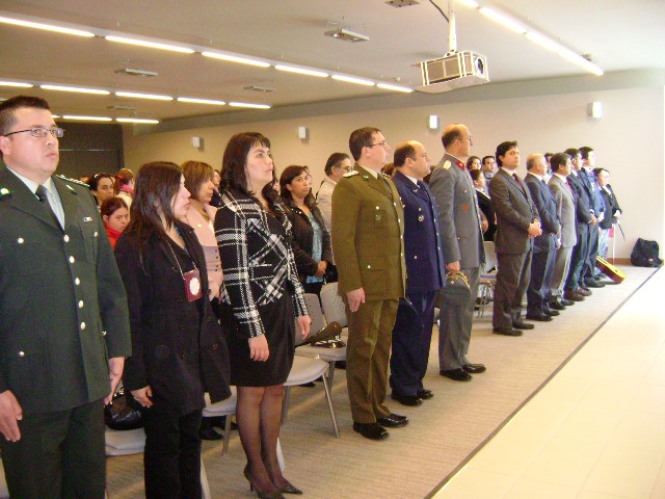 Autoridades regionales entonan el himno nacional en la celebración institucional.