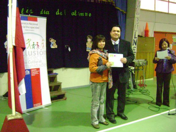 El profesional del Senadis Francisco Diez entregando el reconocimiento a una de las mamás de la escuela.