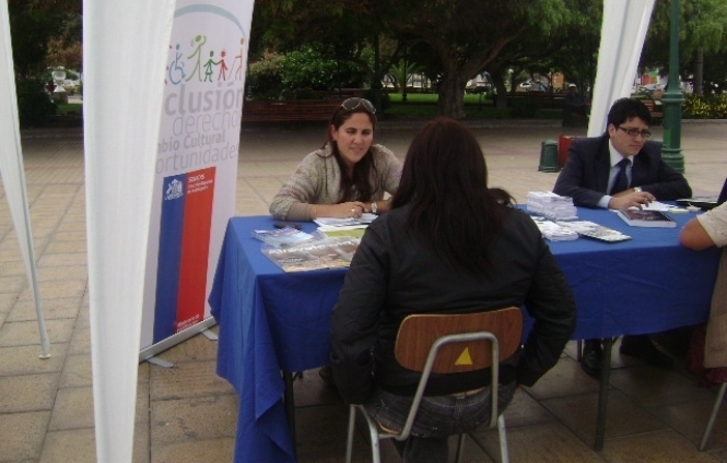 La profesional de la Dirección Regional de Antofagasta entregando información en el stand Senadis