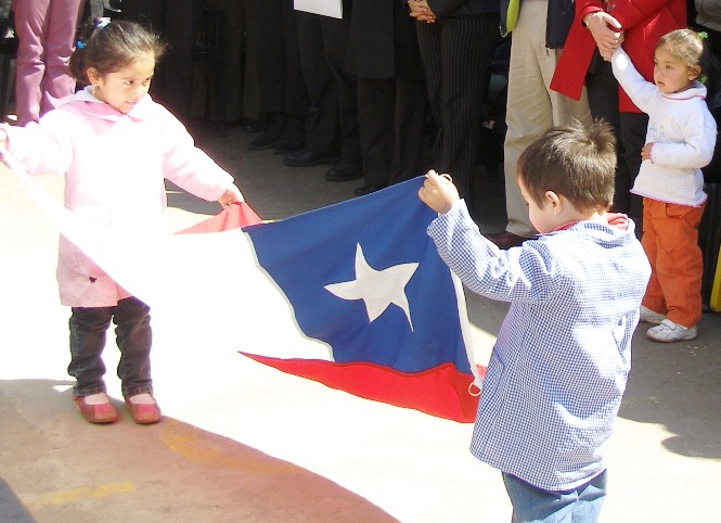 Niños sostienen la bandera chilena.