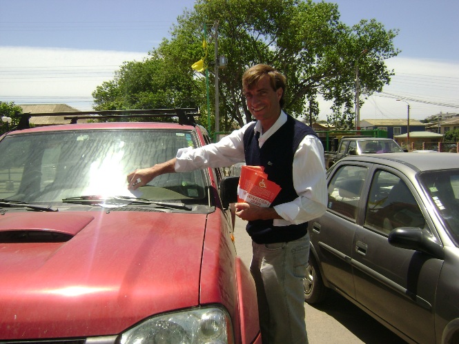 Francisco Subercasaeaux poniendo un volante de la campaña en un automóvil. 