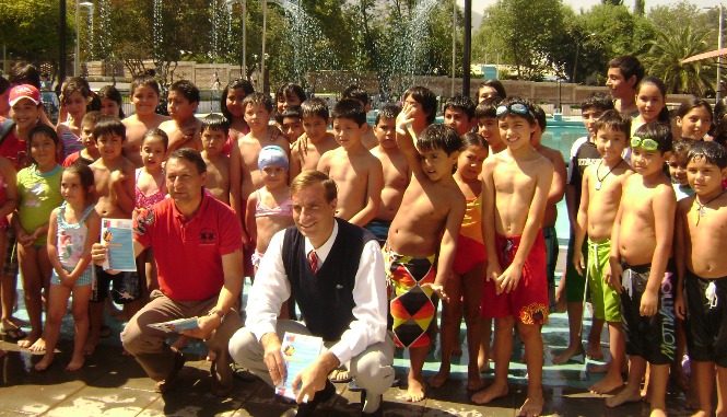 En piscina de Machalí el Director Regional del Senadis junto al Alcalde y niños dan a conocer campaña de prevención.