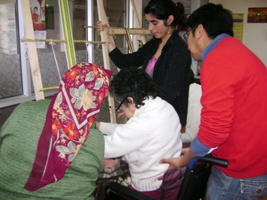 Rosa Colimil enseña el arte del telar a una persona con discapacidad física