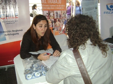 La profesional del SENADIS, Jocelyn Franco, entregando información en el stand institucional.
