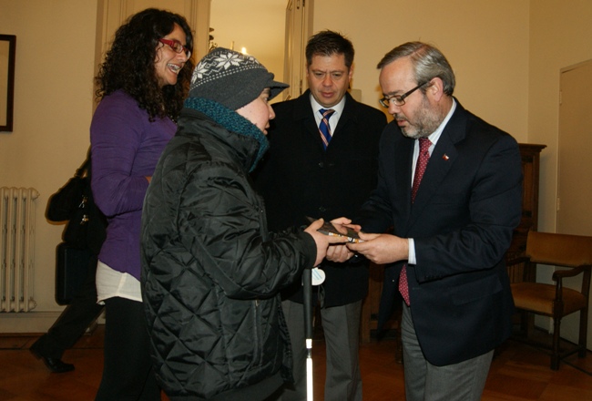 Marcos Abarzúa, joven sordociego, hace entrega de una copia del documental al Ministro Baranda. 